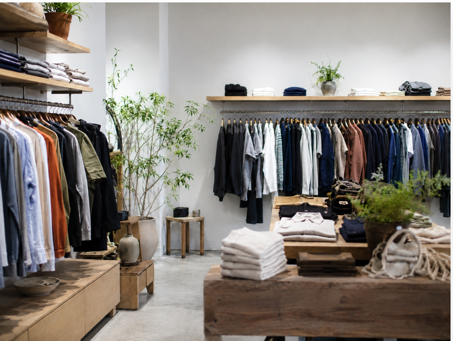 Modern retail store interior lit with warm, even LED track lighting highlighting clothing displays
