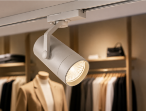Adjustable LED track spotlight highlighting clothing display in a retail store