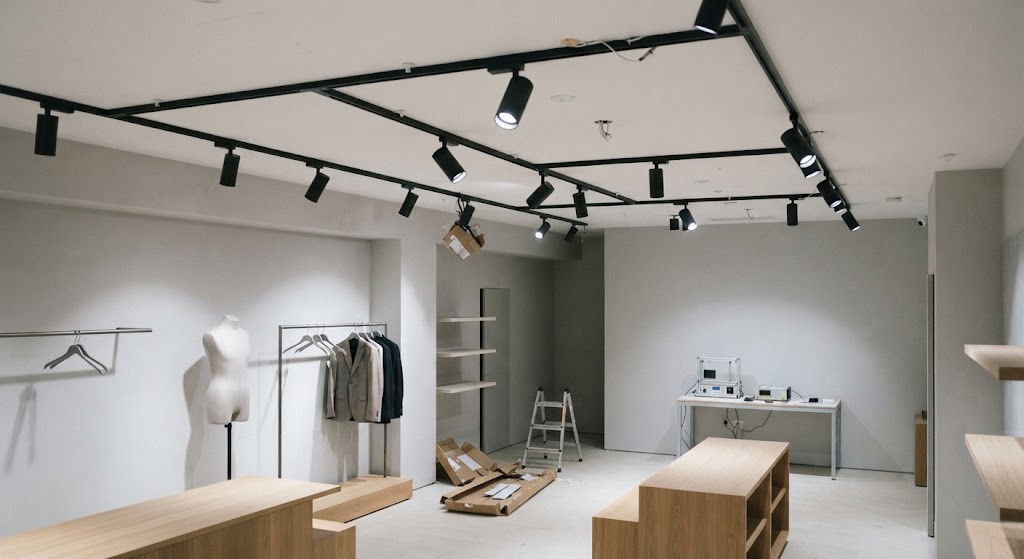 Completed premium retail store with 4000K dimmable DALI track spotlights providing layered accent and ambient lighting.